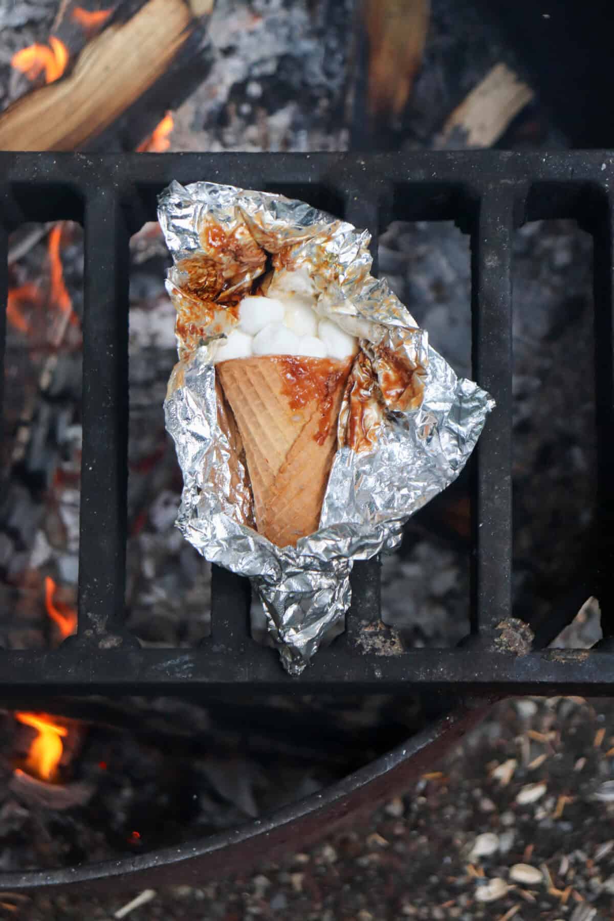 Sugar cone topped with chocolate and marshmallows wrapped in foil.