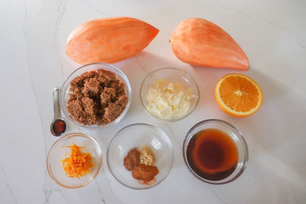 Caramelized sweet potato ingredients in clear glass bowls on a white counter.