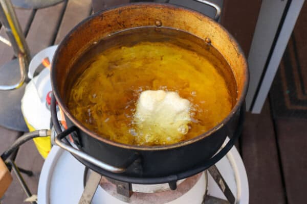 Beer battered cod in a pot of oil.