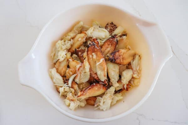 Large pieces of cooked crab meat in a white bowl.