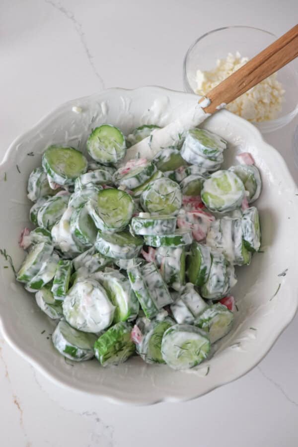 Tzatziki cucumber salad ingredients in a white mixing bowl.