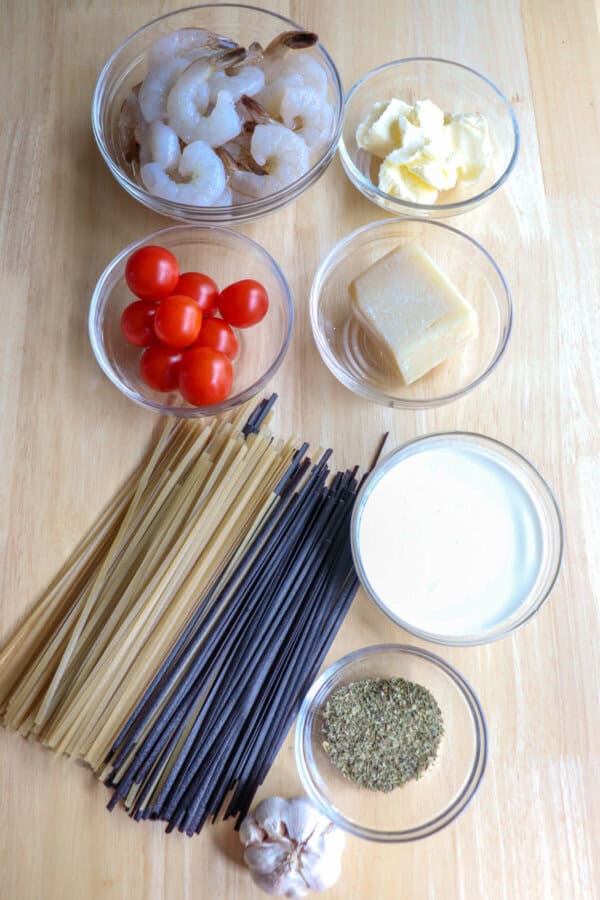 Ingredients for shrimp linguine on a wooden table.