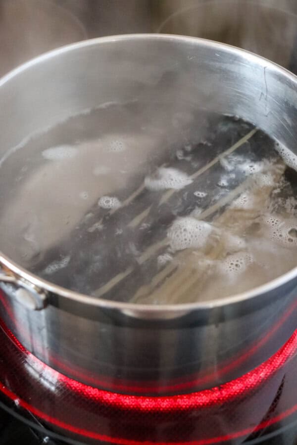 Black and white linguini noodles in a pot of boiling water.