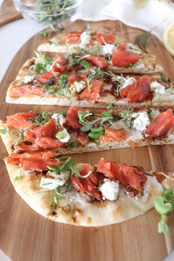 Flatbread topped with cream cheese, smoked salmon pieces, mustard greens, crumbled goat cheese and drizzled with balsamic vinegar cut into 1" strips.