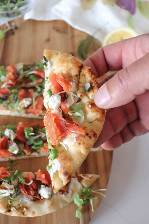 Flatbread topped with cream cheese, smoked salmon pieces, mustard greens, crumbled goat cheese and drizzled with balsamic vinegar cut into 1" strips.