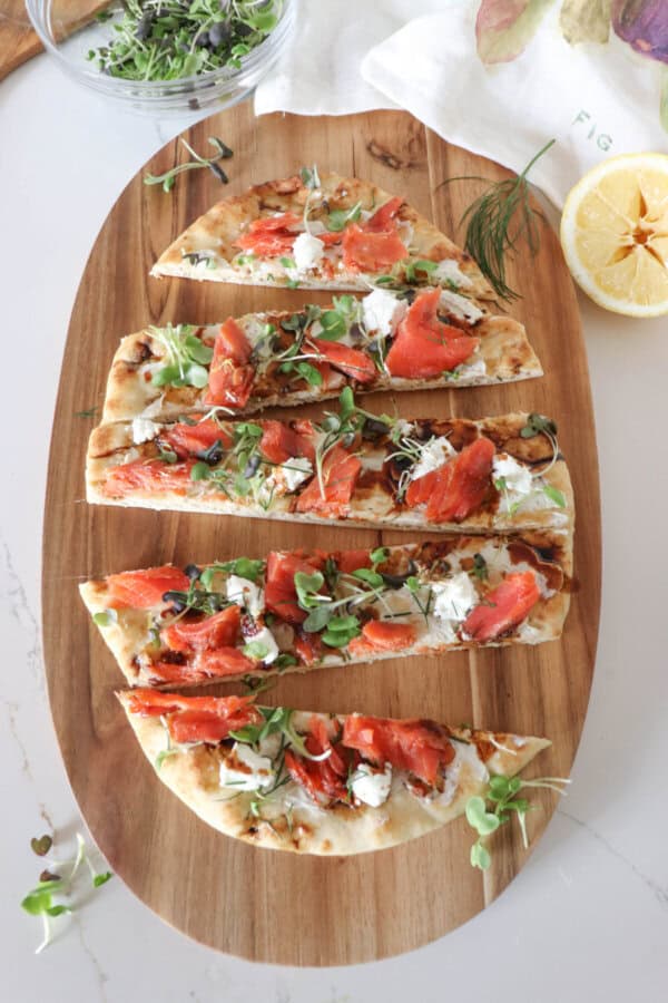 Flatbread topped with cream cheese, smoked salmon pieces, mustard greens, crumbled goat cheese and drizzled with balsamic vinegar cut into 1" strips.