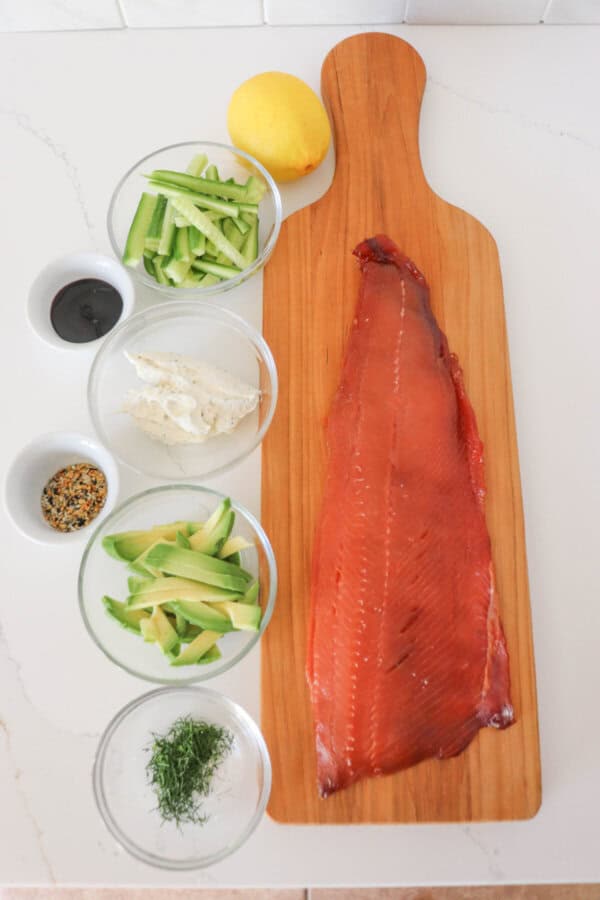 Ingredients for smoked salmon roll ups on a white counter.