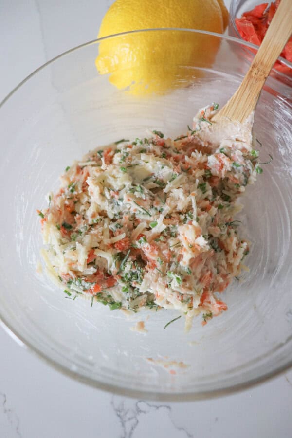 Ingredients for smoked salmon spaghetti sauce mixed in a medium glass bowl.