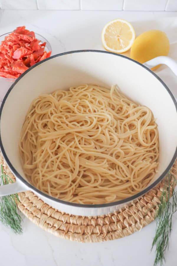 Cooked spaghetti in a white dutch oven.