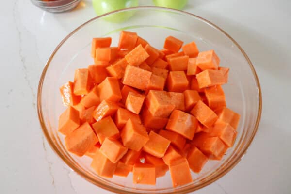 Sweet potatoes cut into cubes in a clear glass bowl.