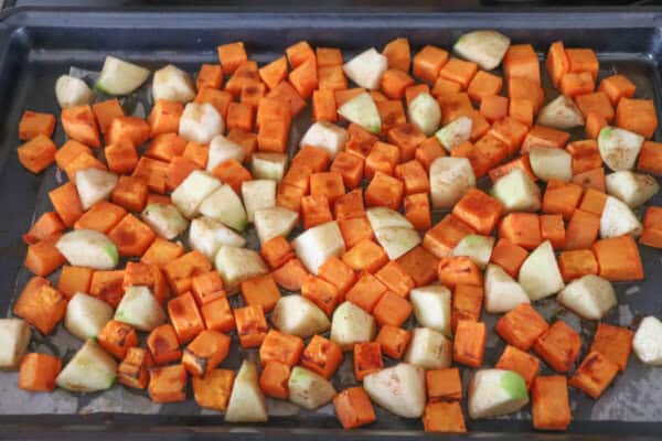Cubbed sweet potato and apples on a baking sheet.