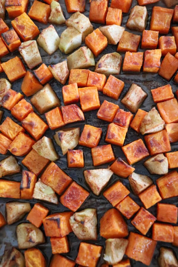 Cubbed sweet potato and apples on a baking sheet.
