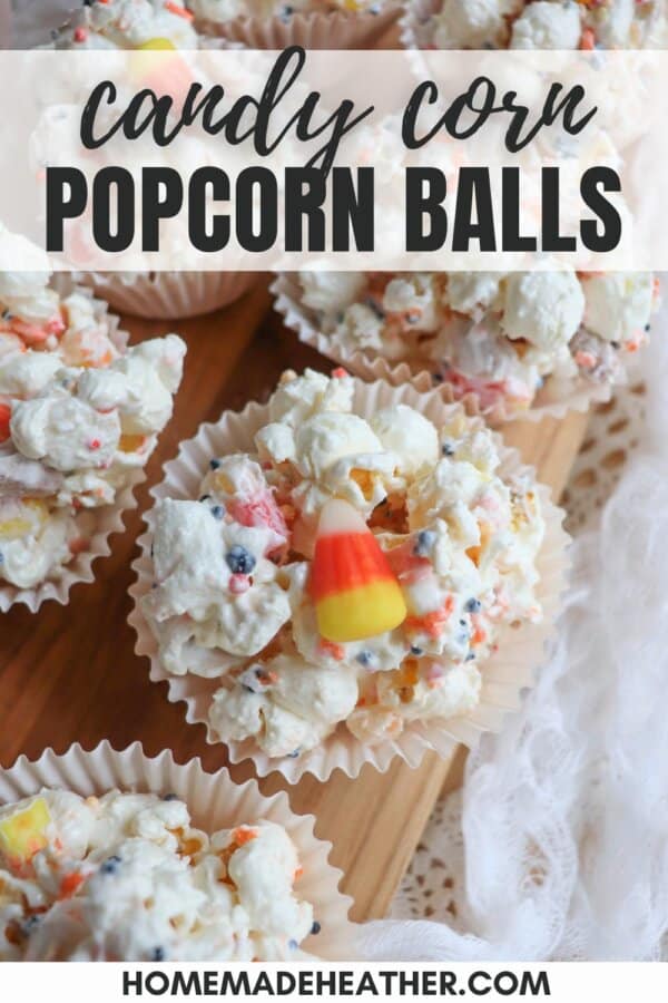 Popcorn balls with Halloween sprinkles and candy corn in cupcake liners on a wooden cutting board.