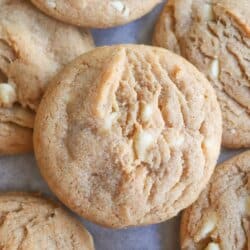 Caramel colored pumpkin spice cookies with white chocolate chips layered on top of each other.