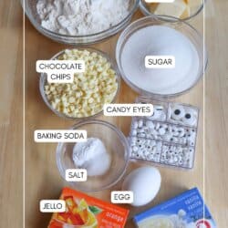 Ingredients for Halloween pudding cookies in clear glass bowls on a wooden table.