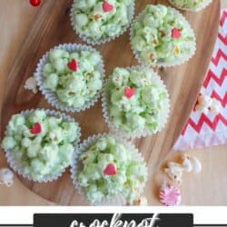 Green popcorn balls in white cupcake liners topped with a red candy heart.