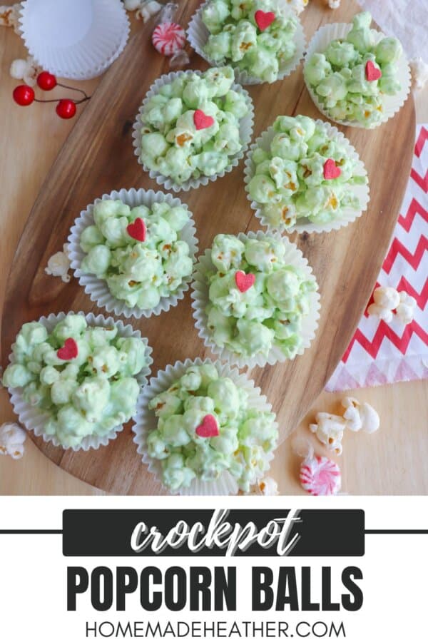 Green popcorn balls in white cupcake liners topped with a red candy heart.