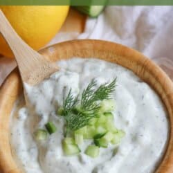 Creamy white tzatziki sauce with diced cucumber and dill garnish.