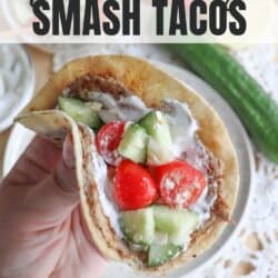 Tortilla with cooked ground turkey, diced cucumber, tomato and tzatziki sauce held in a hand.