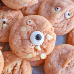 Orange pudding cookies with candy eyes stacked on top of each other.