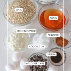 Ingredients for oatmeal protein cookies in clear glass bowls in a white counter.