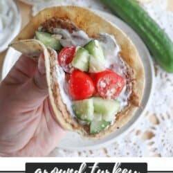Tortilla with cooked ground turkey, diced cucumber, tomato and tzatziki sauce held in a hand.