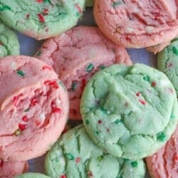 Pink and green cookies with Christmas sprinkles stacked on one another.