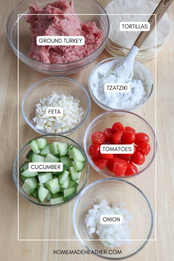 Ingredients for turkey smash tacos in clear glass bowls on a wooden table.