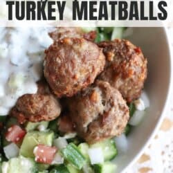 Meatballs in a bed of rice with tzatziki and diced cucumber.