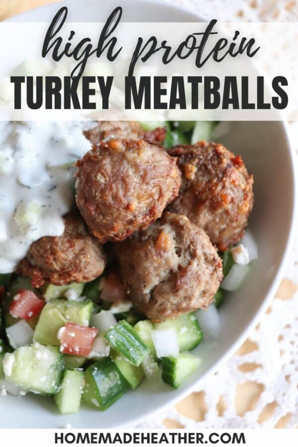 Meatballs in a bed of rice with tzatziki and diced cucumber.