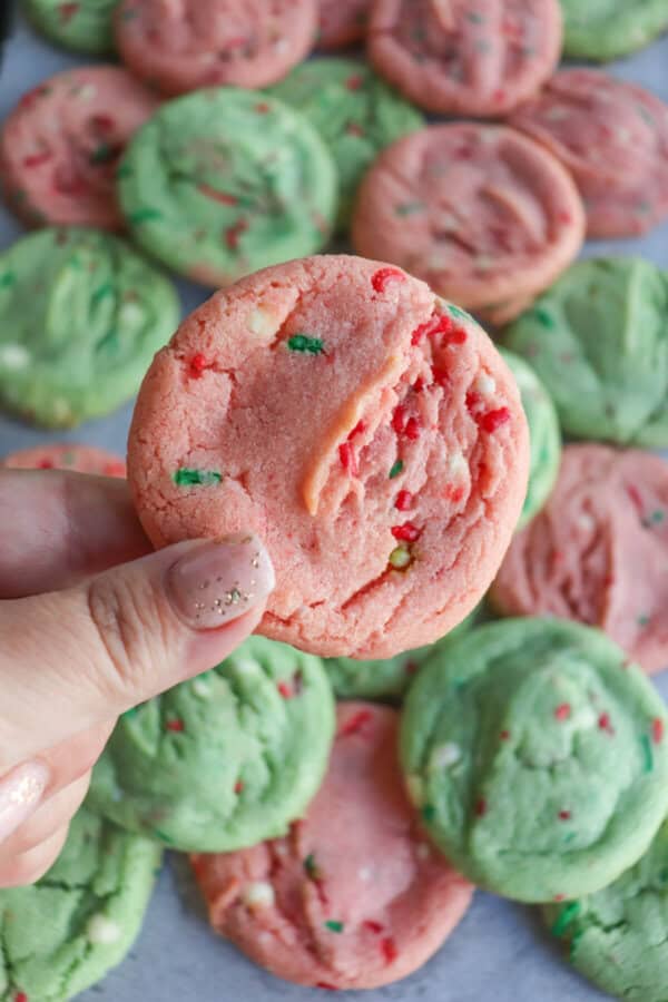 Pink and green cookies with Christmas sprinkles stacked on top of one another.