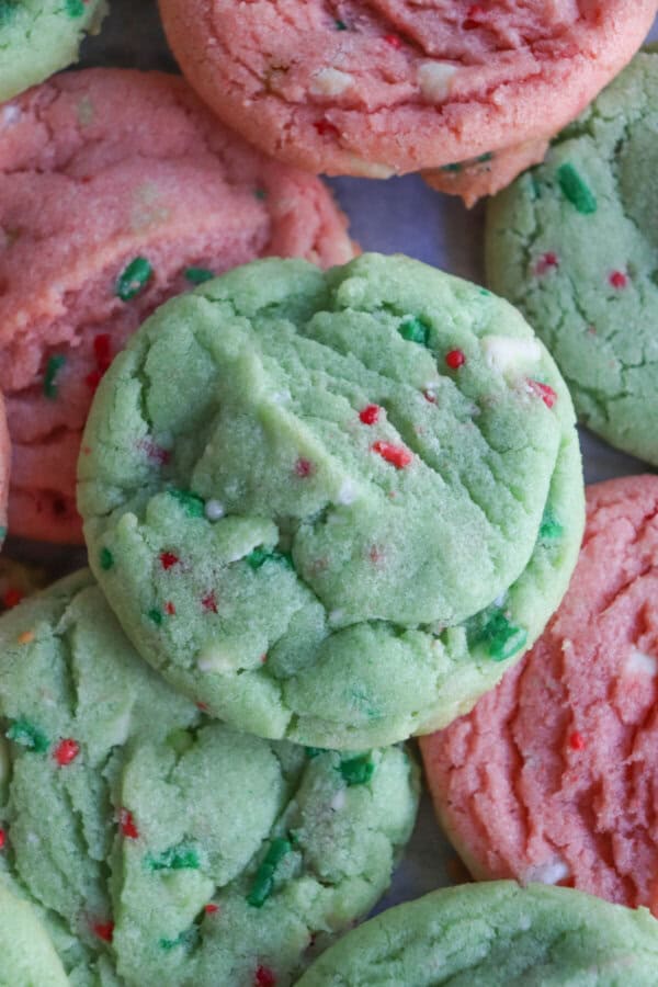 Pink and green cookies with Christmas sprinkles stacked on top of one another.
