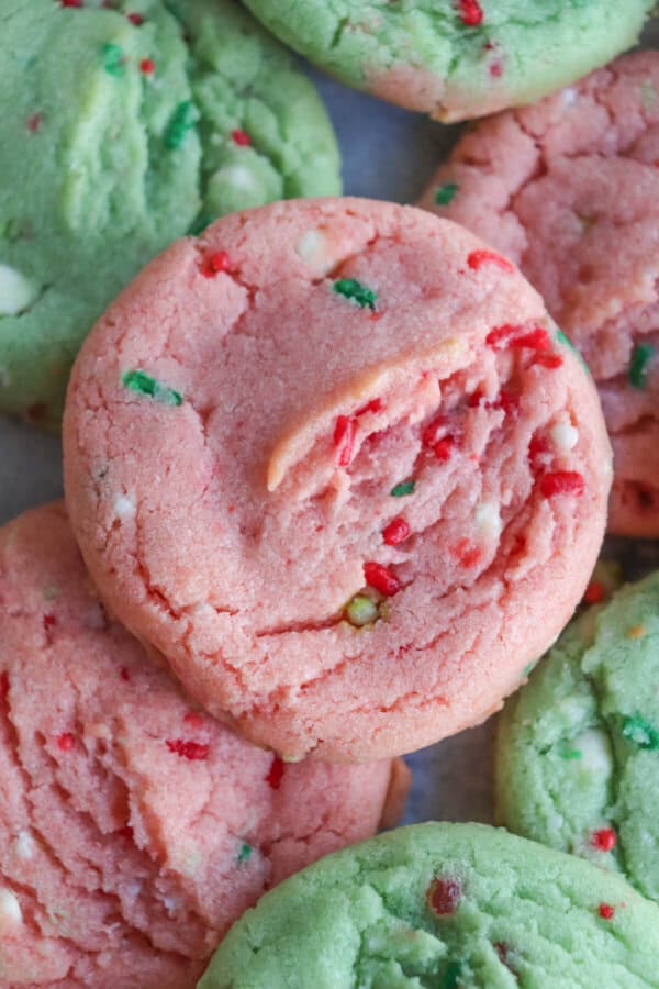 Pink and green cookies with Christmas sprinkles stacked on top of one another.