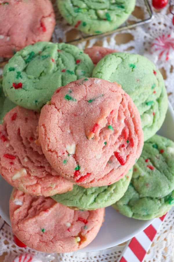 Pink and green cookies with Christmas sprinkles stacked on top of one another.