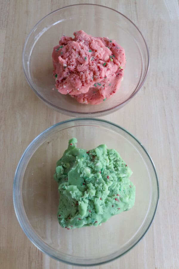 Green and pink cookies dough in two separate bowls.