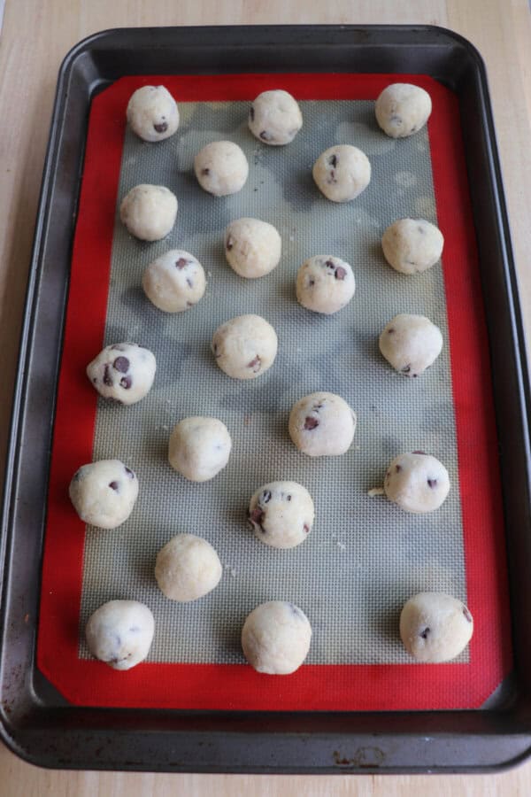 Cottage cheese cookie dough balls on a lined cookie sheet.