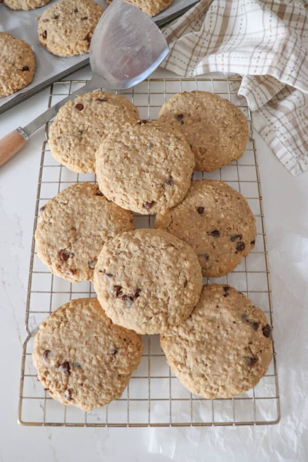 Large oatmeal chocolate chip cookies stacked on one another.