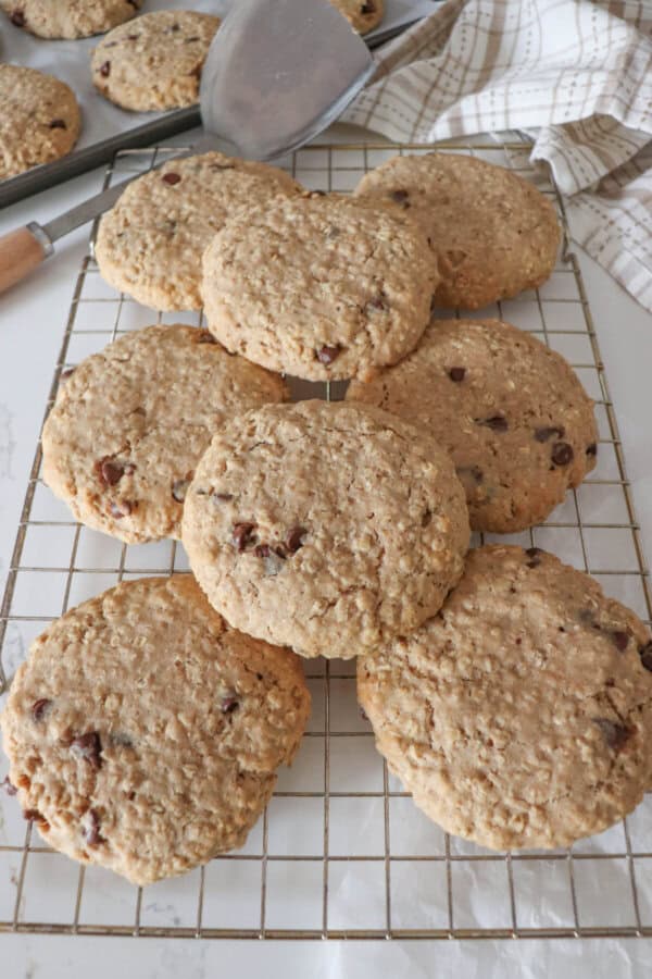 Large oatmeal chocolate chip cookies stacked on one another.