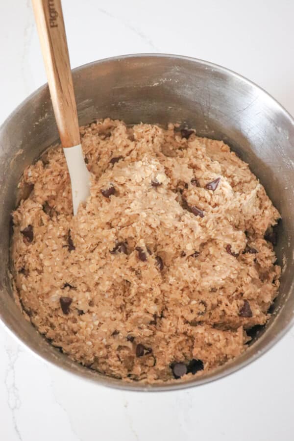 Chocolate chip oatmeal protein cookie dough in the bowl of a stand mixer.