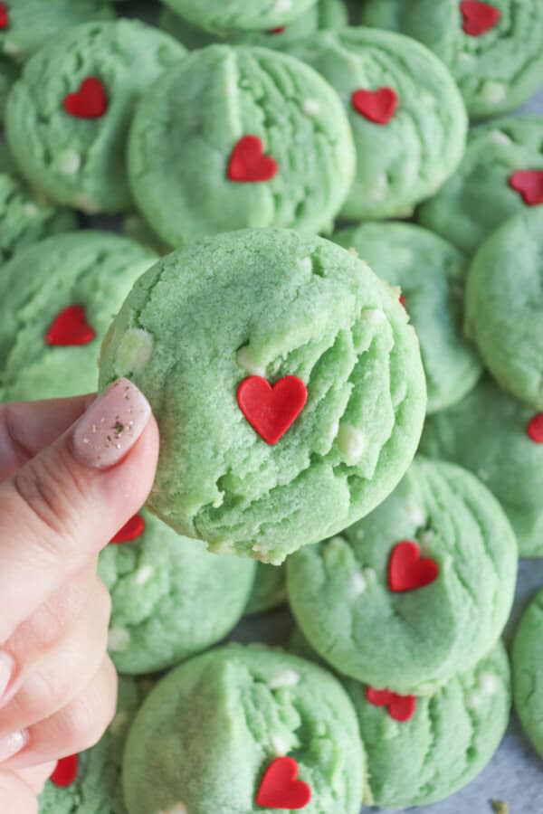 Green pudding cookies with a red candy heart stacked on top of each other.