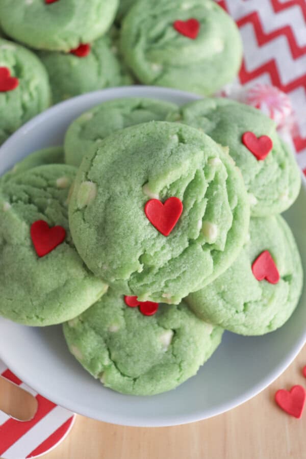 Green pudding cookies with a red candy heart stacked on top of each other.