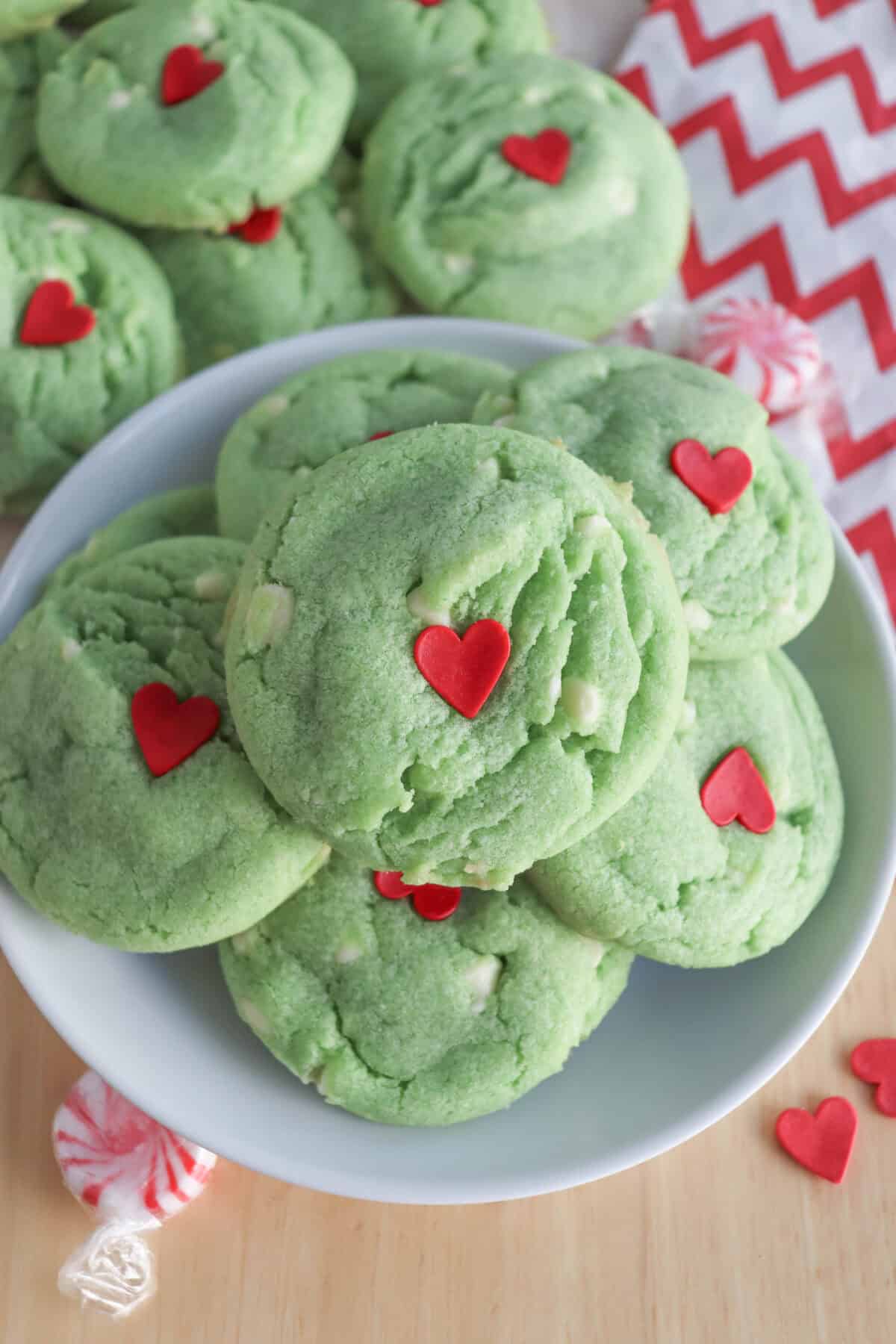 Green pudding cookies with a red candy heart stacked on top of each other.