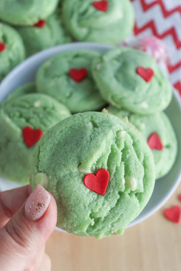 Green pudding cookies with a red candy heart stacked on top of each other.