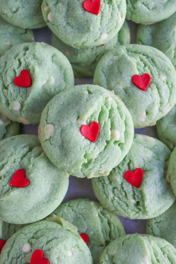 Green pudding cookies with a red candy heart stacked on top of each other.