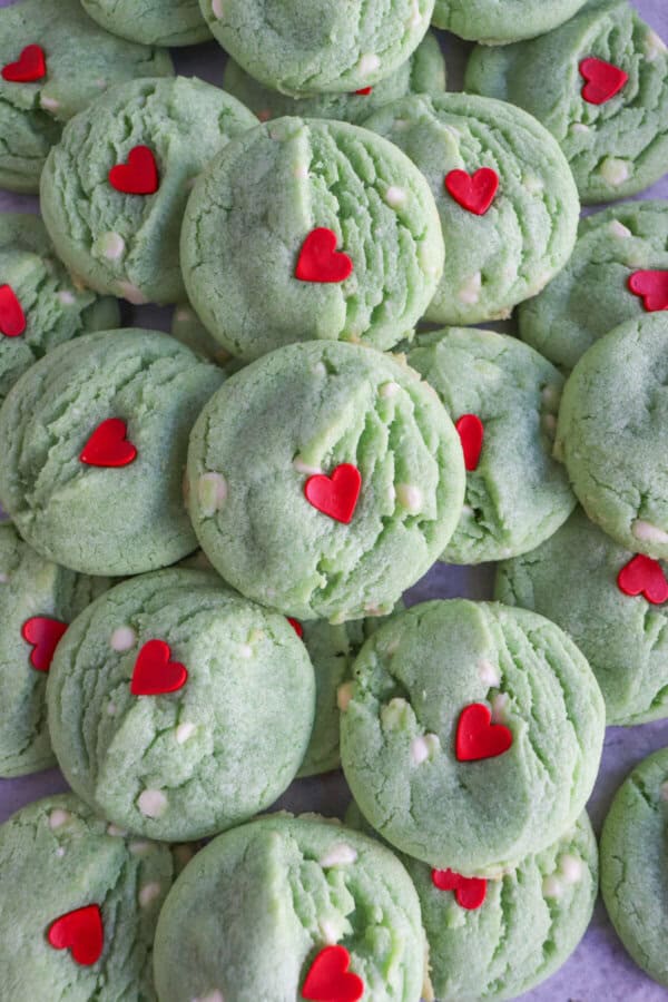 Green pudding cookies with a red candy heart stacked on top of each other.
