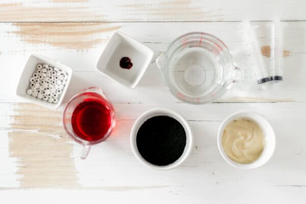 Ingredients for monster mocktails in bowls on a white table.