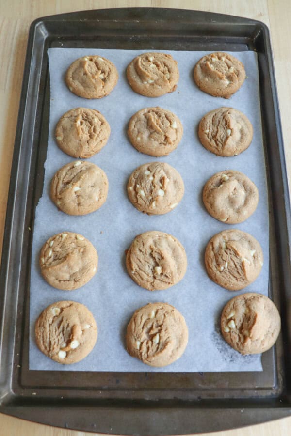 Pumpkin spice cookies on a parchment paper lined baking sheet.