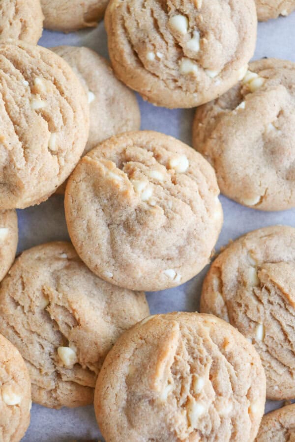 Caramel colored pumpkin spice cookies with white chocolate chips layered on top of each other.