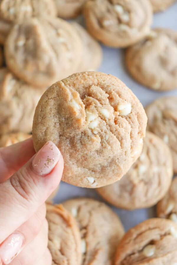 Caramel colored pumpkin spice cookies with white chocolate chips layered on top of each other.