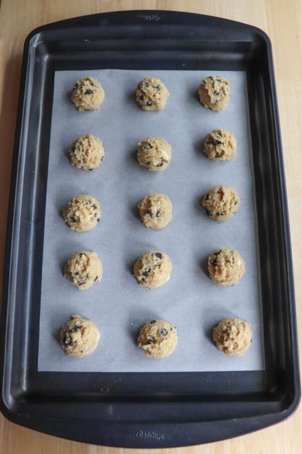 Cottage cheese cookie dough balls on a parchment paper lined cookie sheet.